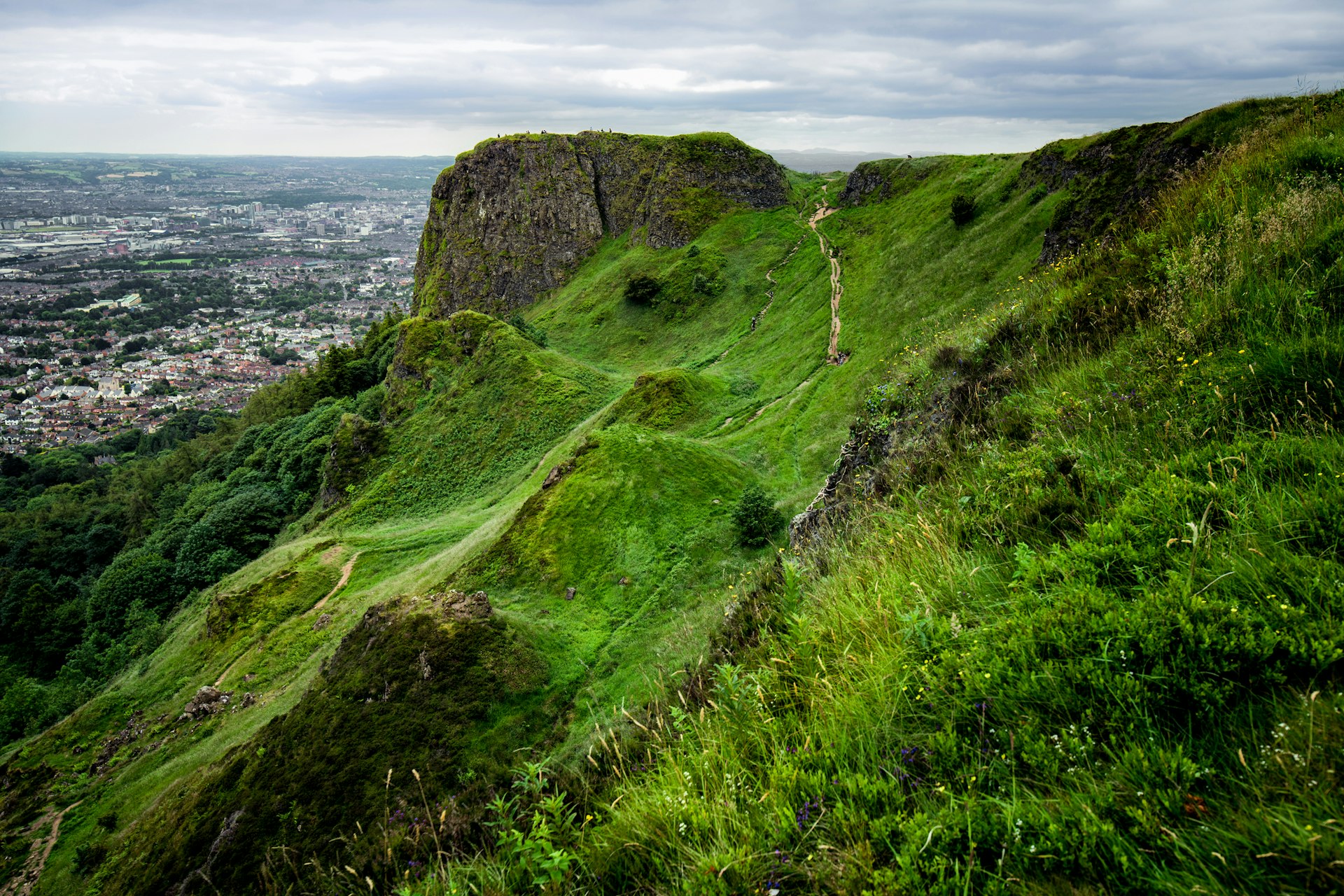 The emerald green hulk of Cave Hill Country Park in Belfast, Northern Ireland stands above the city and is crisscrossed with hiking paths