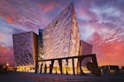 BELFAST, NORTHERN IRELAND - JUNE 28, 2017: Sunset over Titanic Belfast - museum, touristic attraction and monument to Belfast's maritime heritage on the site of the former Harland and Wolff shipyard.; Shutterstock ID 1847358820; your: Jennifer Carey; gl: 65050; netsuite: Online Editorial; full: Belfast best museums