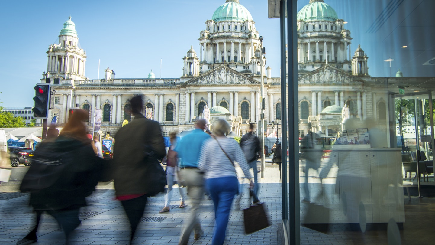 Motion blurred shoppers in front of Belfast city hall in Northern Ireland