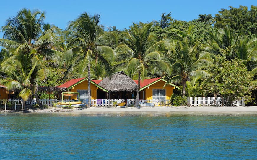 Low-rise hostel on the beach surrounded by palm trees