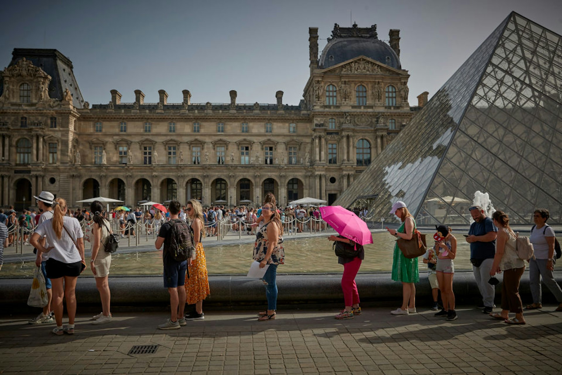 Tourists queue for entry into the Louvre Museum, Paris,