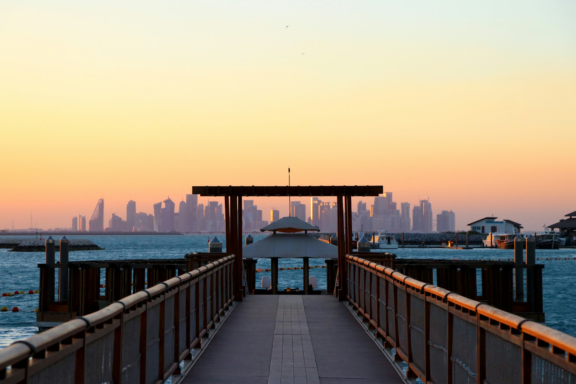 View over water at sunset to a city skyline with many high-rise buildings