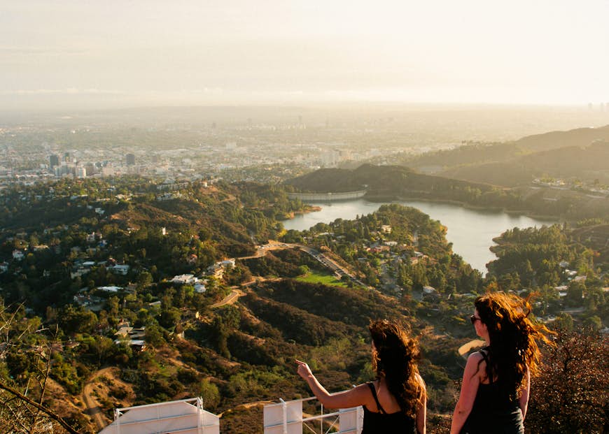 Two woman looking out over the Los Angeles skyline. 