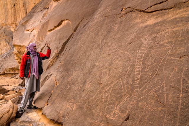Guide, Abdessalam, showing rock carvings in Tassili National Park