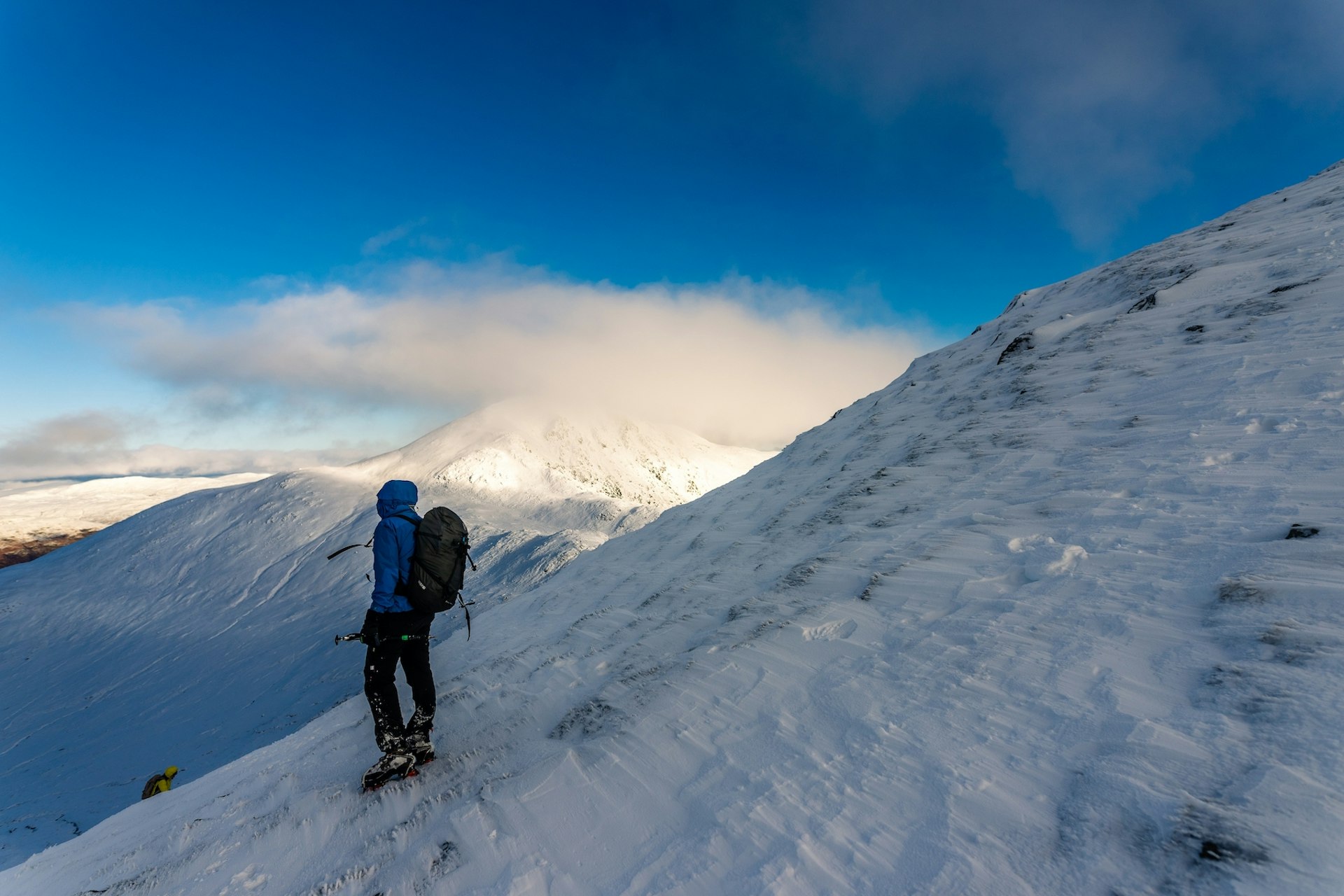 A man hikes in the snow in the Highlands, Scotland, United Kingdom