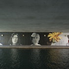 Indianapolis, Indiana, USA - April 10, 2015: Two people ride a tandem bicycle past a mural on the popular Canal Walk in Indianapolis, Indiana. The waterway is part of the historic Indiana Central Canal, constructed in the early 1800s.