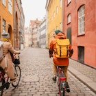 Photo of a young couple riding bicycles and enjoying the lovely winter morning in the city.