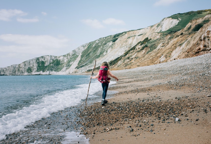 girl walking along the Jurassic coast with a stick on a beautiful day