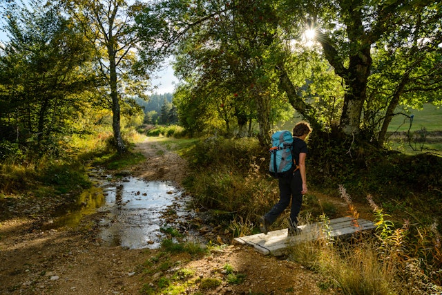 Hiker on the Robert Louis Stevenson Trail approaching Chasserades in the Cevennes, Lozere, France