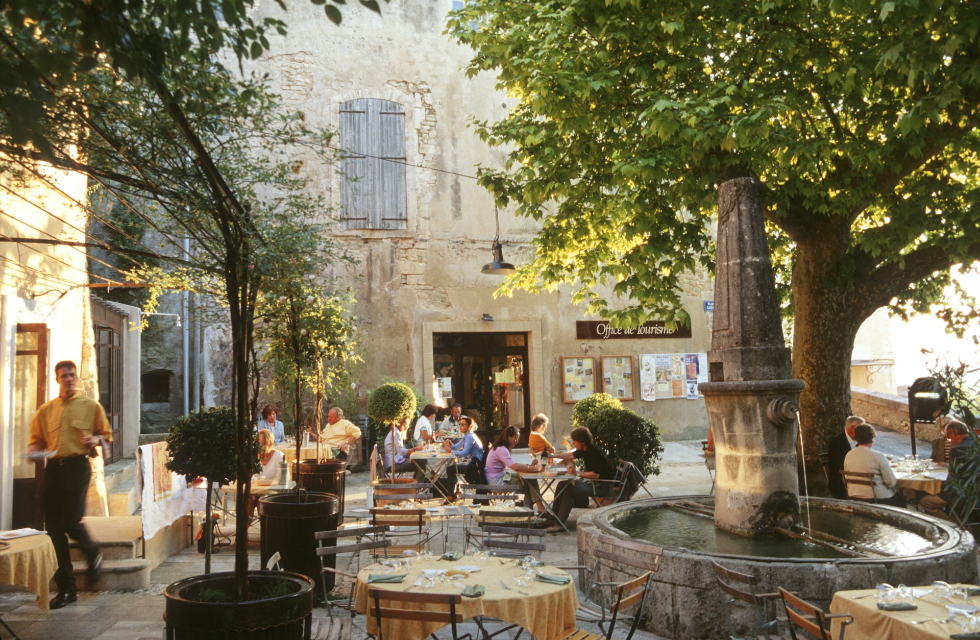 People relaxing on a restaurant terrace in a village in France