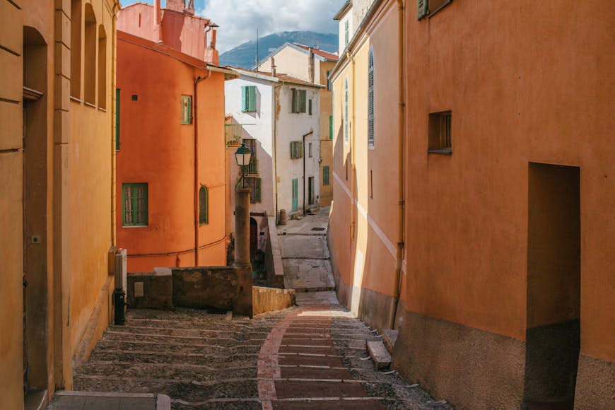 Stone steps and the facades of stucco houses in the historic center of Menton, Côte d’Azur, France