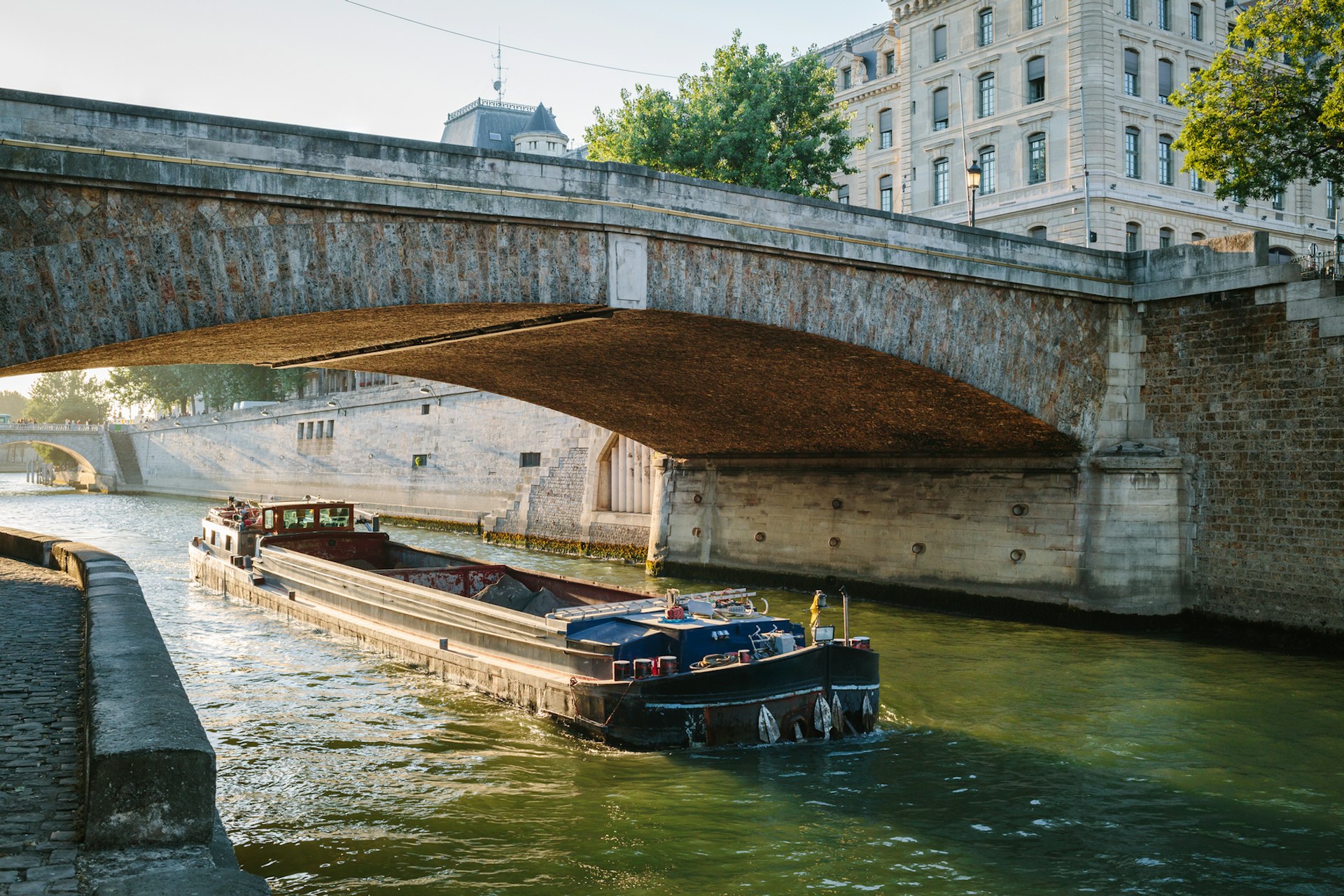 The Petit Pont over the Seine river and a barge in Paris, France