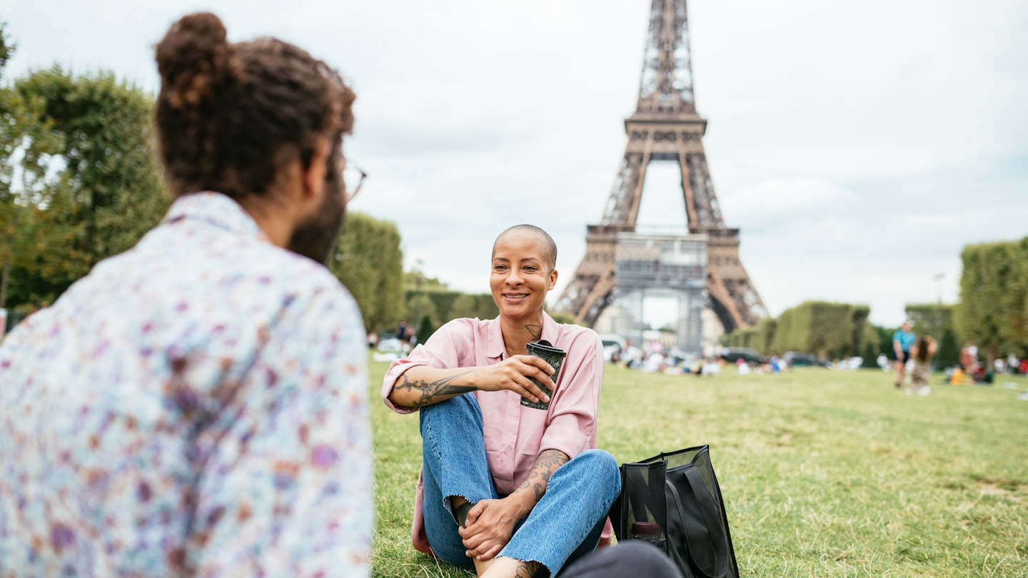People enjoying relaxing or working near Eiffel tower in Paris, France