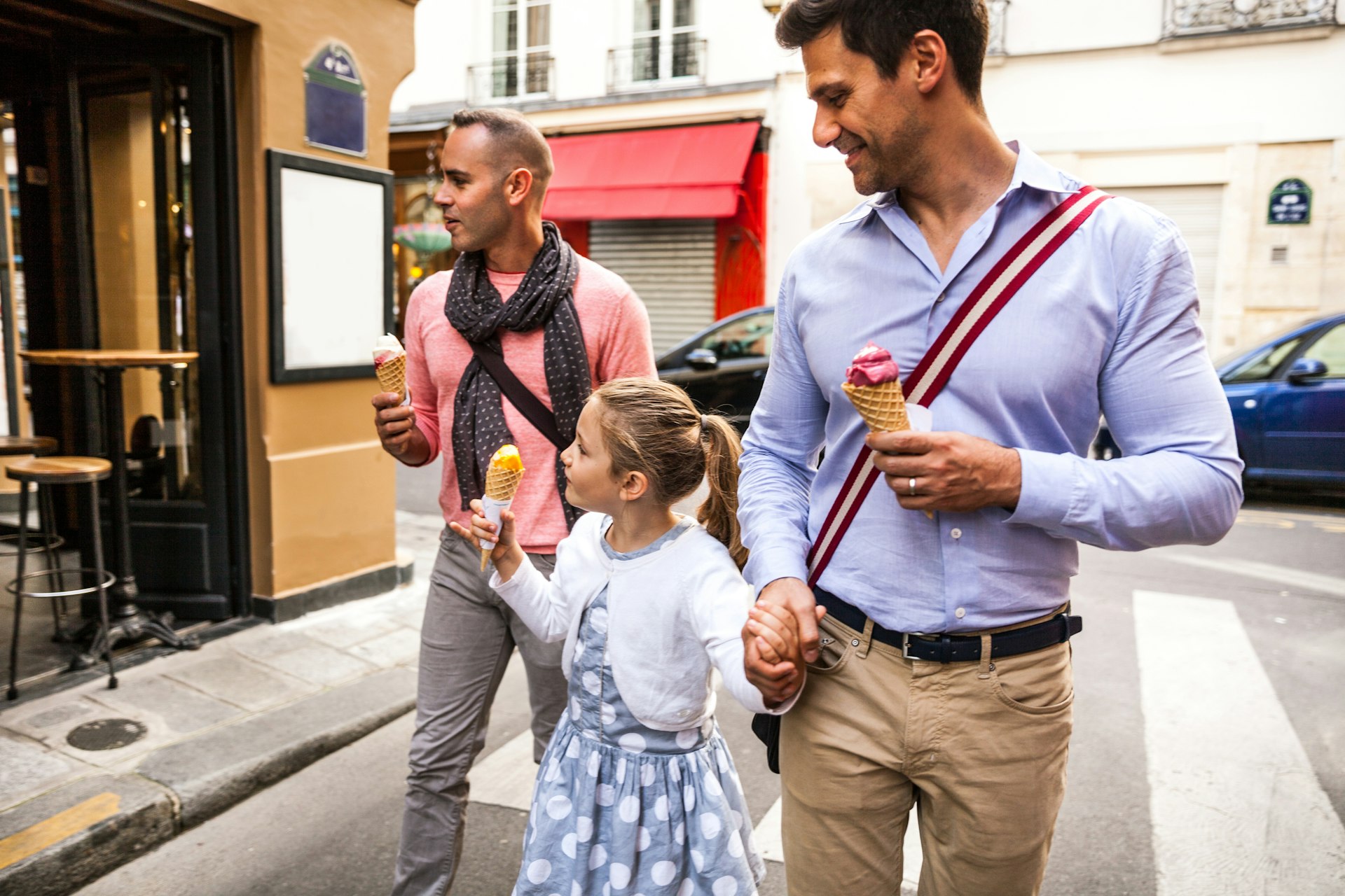 Gay male couple walks with young daughter, all with ice cream cones, Paris, Île de France, France