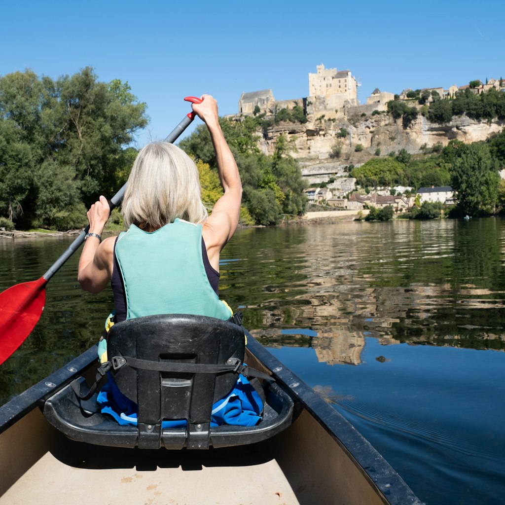 Woman canoeing on the Dordogne River from La Roque Gageac to Beynac et Cazenac in the Dordogne region of France.