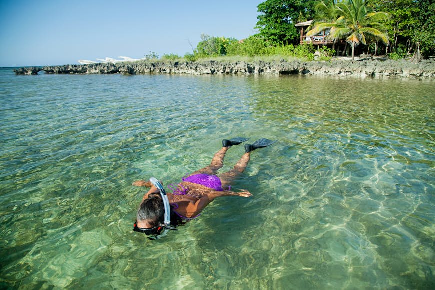 Young woman snorkelling in shallow water in Honduras