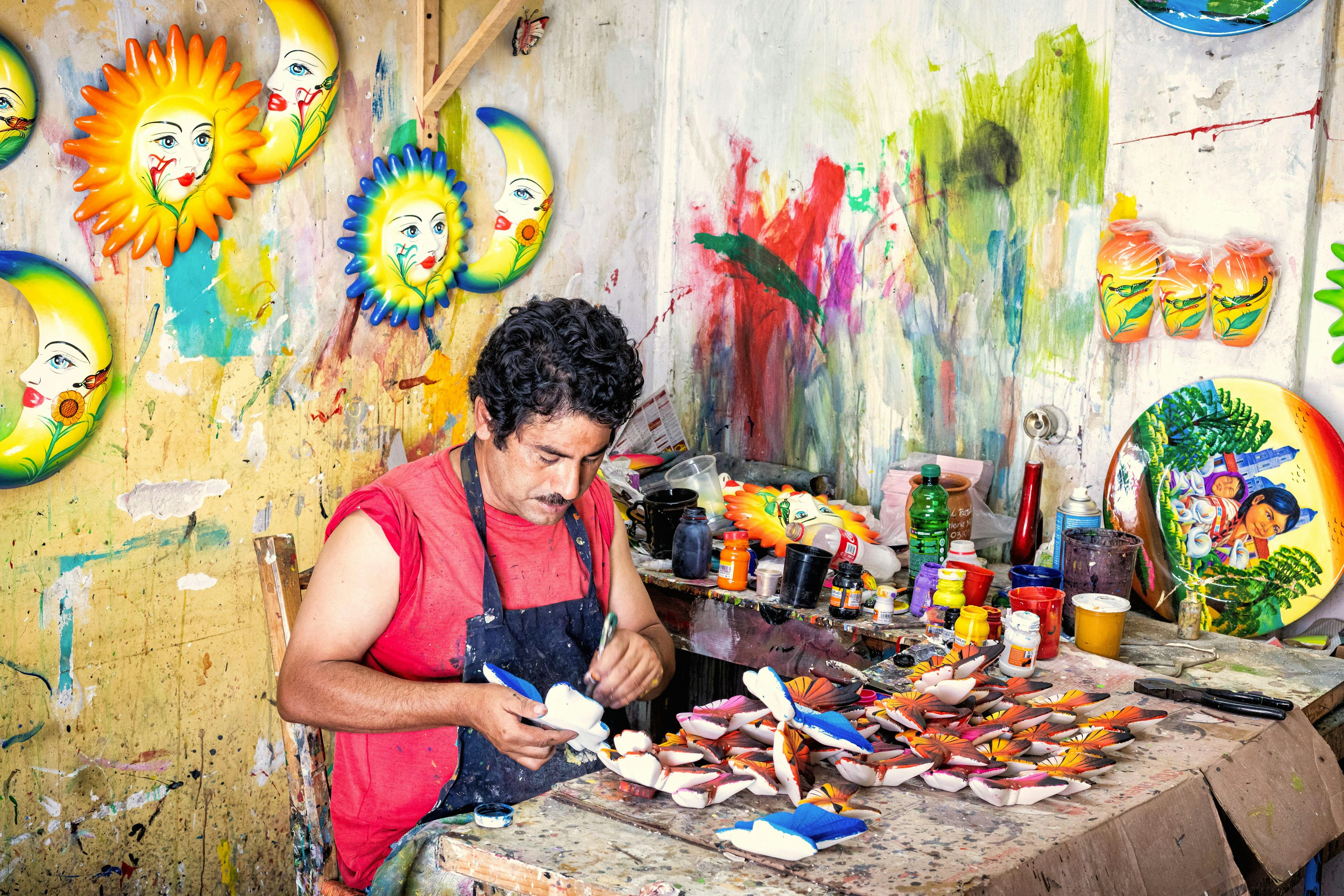 An artisan paints ceramic figures in the popular market of Tonala