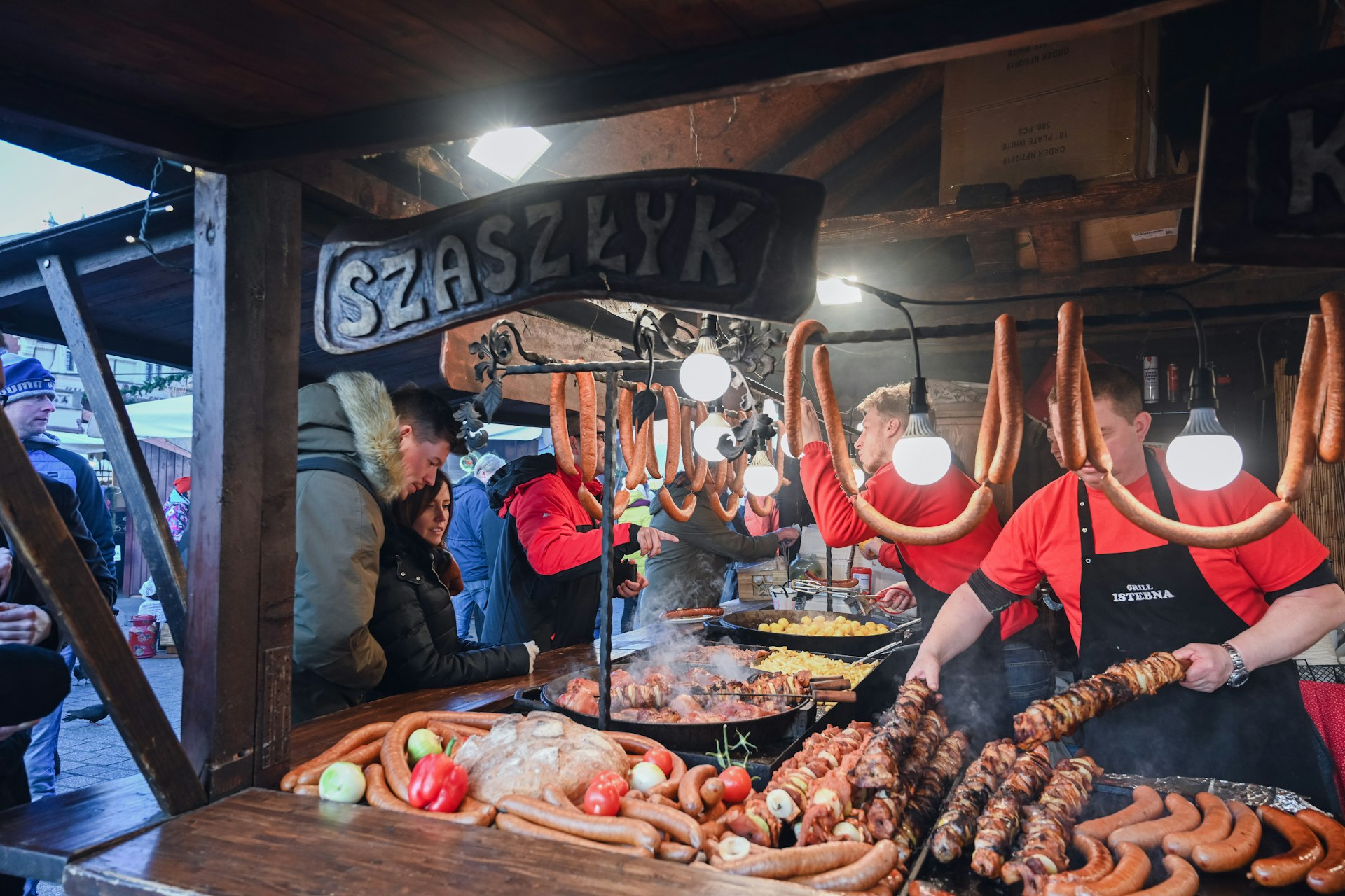 Chefs cooking and serving traditional Polish hot food at a market in Krakow