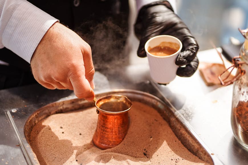 A man prepares Turkish coffee in burning sand in Souq Waqif, Doha, Qatar, Middle East