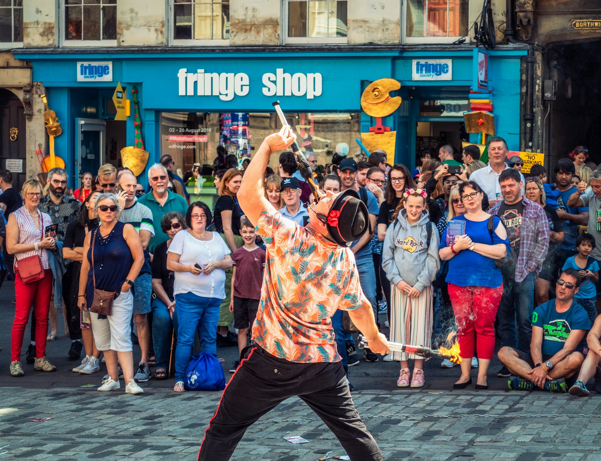 Crowds watch a fire-eating street performer during the Edinburgh Festival, Edinburgh, Scotland, United Kingdom