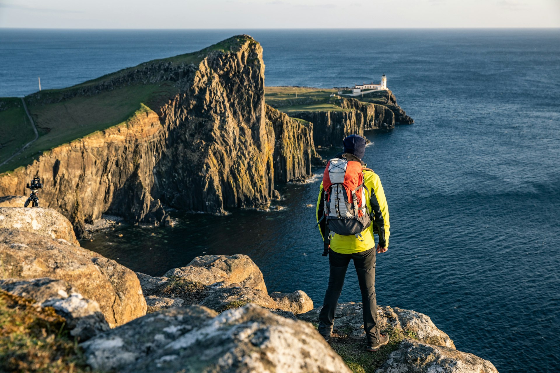 A solo traveler seen from behind, looking out over the Isle of Skye