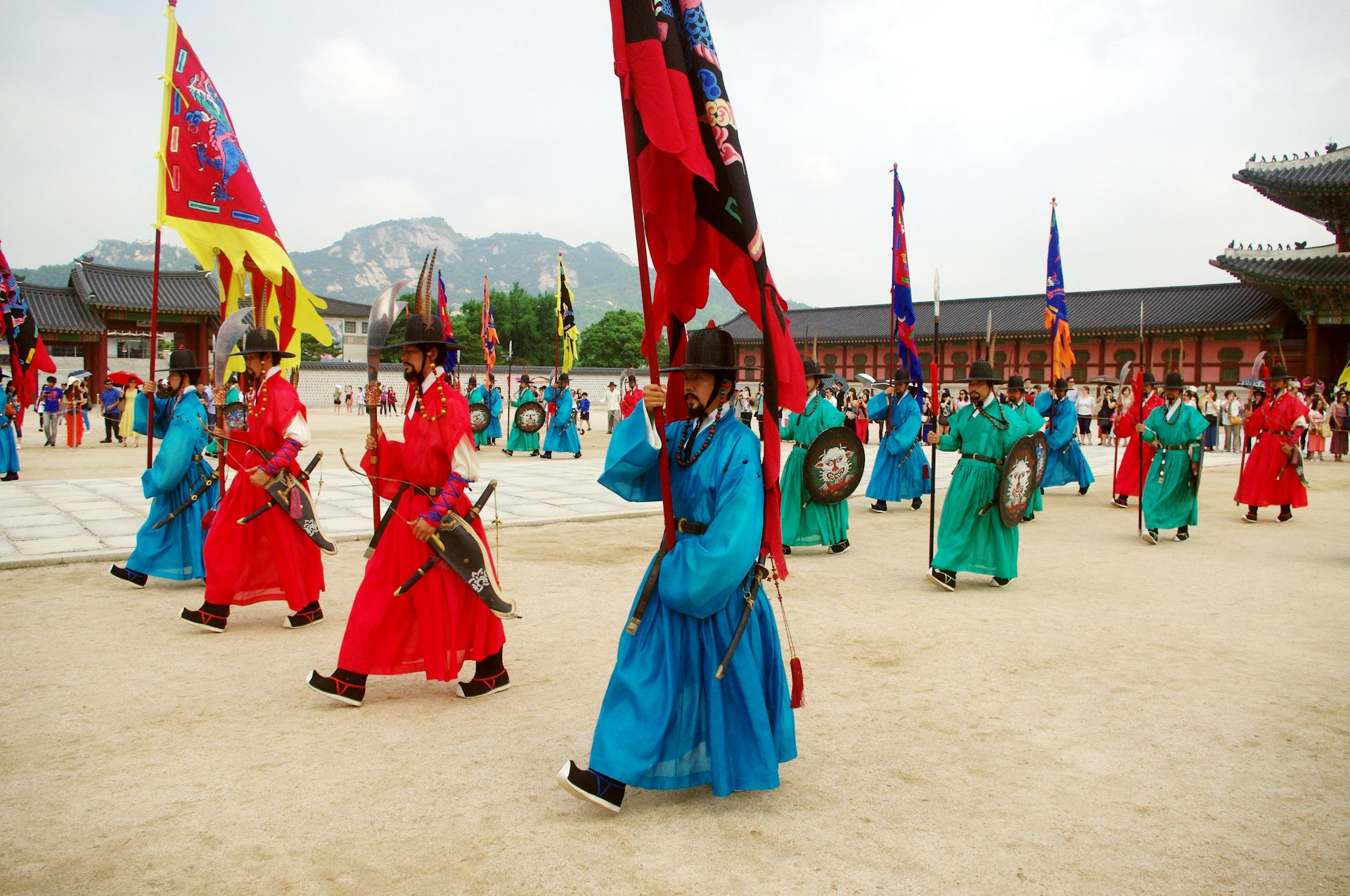 Soldiers in historic uniforms and carrying pennants participate in the changing of the guard ceremony at Gyeongbokgung Palace, Seoul, South Korea