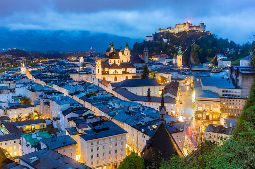 Salzburg skyline with the Fortress Hohensalzburg and the Salzach River during the blue hour