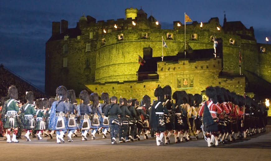 Troops in kilts wtih pipes and drums mass in front of Edinburgh Castle during the annual military tattoo, Edinburgh, Scotland, United Kingdom