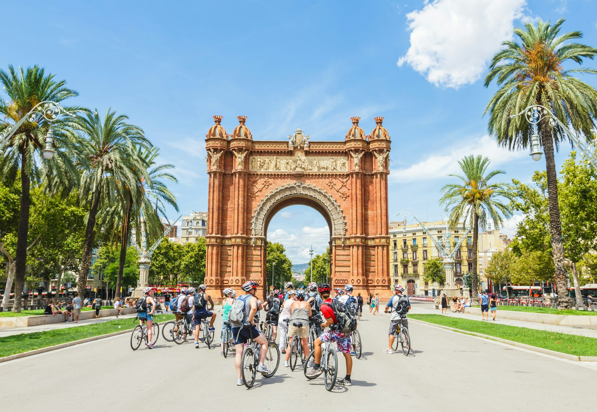 A group of people on bicycles in front of the Arc de Triomf in Barcelona