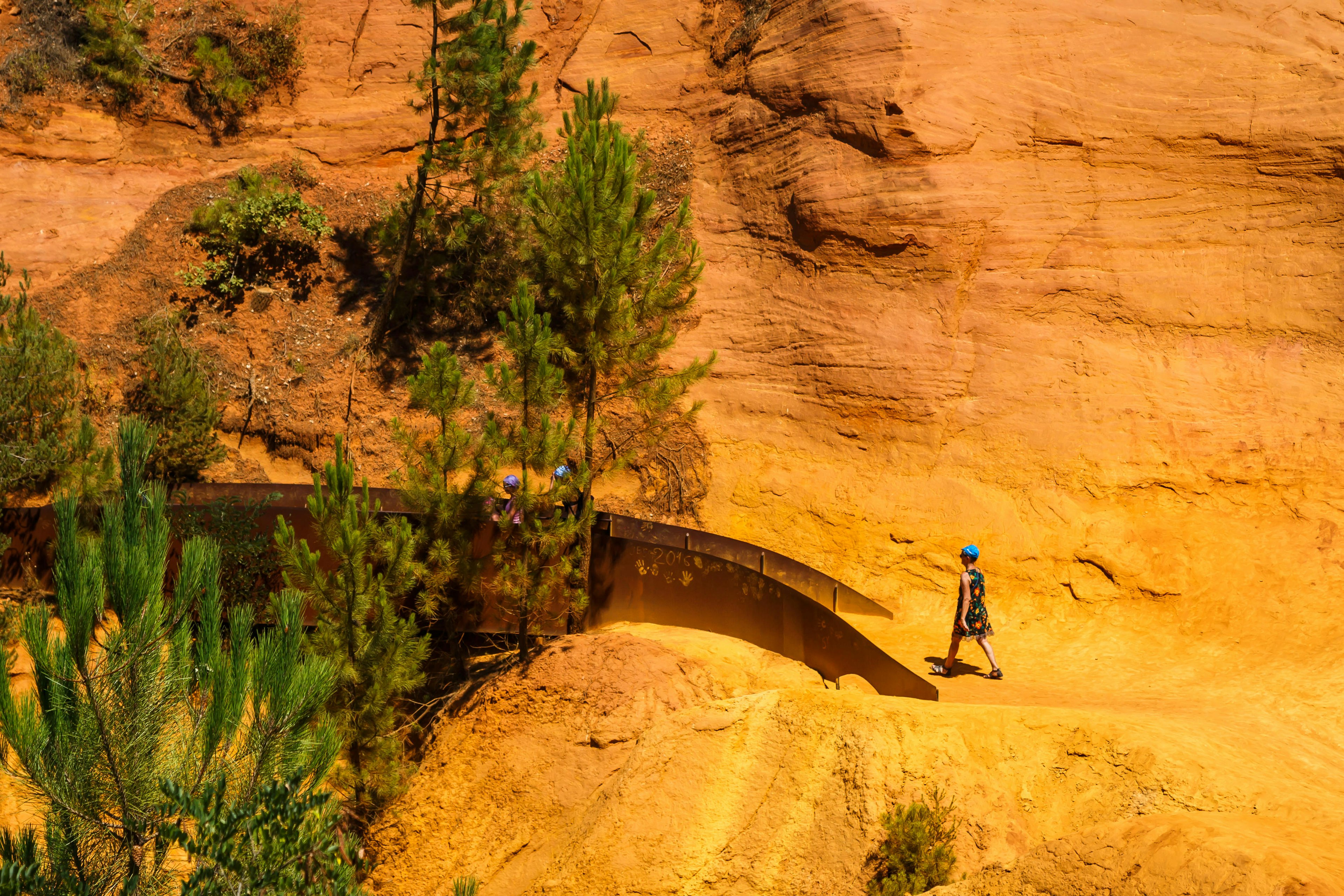 Walkers in an ochre landscape on the Sentiers des Ocres near the village of Roussillon, France