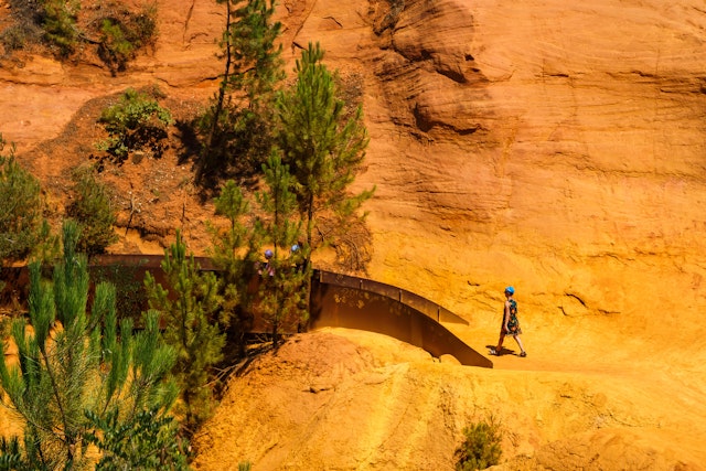 Walkers in an ochre landscape on the Sentiers des Ocres near the village of Roussillon, France