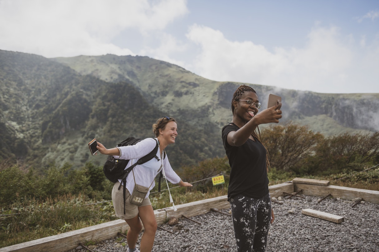 Two young women, from Poland and Israel, pause for a selfie while hiking the Gwaneumsa Trail in Hallasan National Park. Located on Jeju Island, Hallasan is the highest mountain in South Korea.