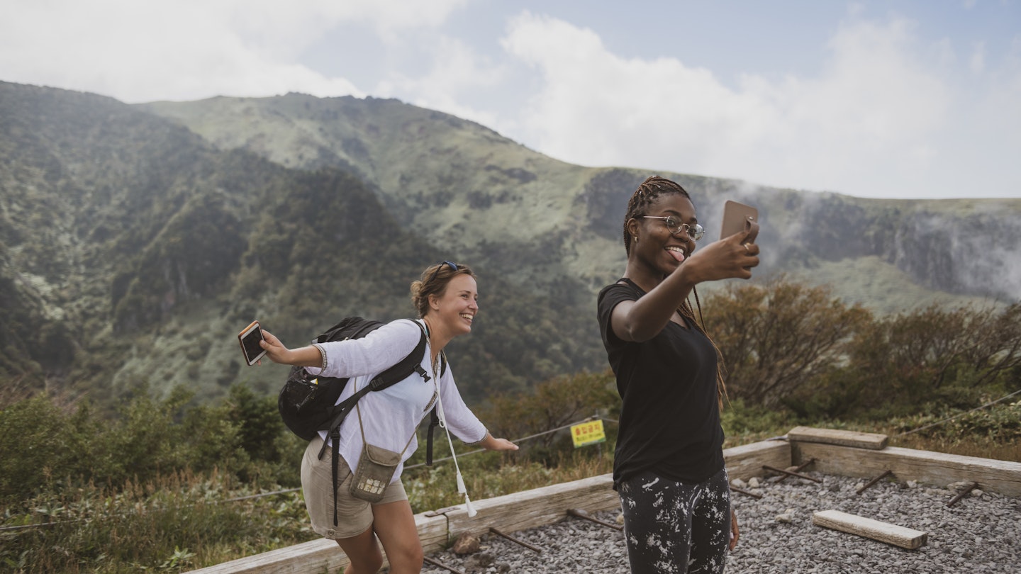 Two young women, from Poland and Israel, pause for a selfie while hiking the Gwaneumsa Trail in Hallasan National Park. Located on Jeju Island, Hallasan is the highest mountain in South Korea.