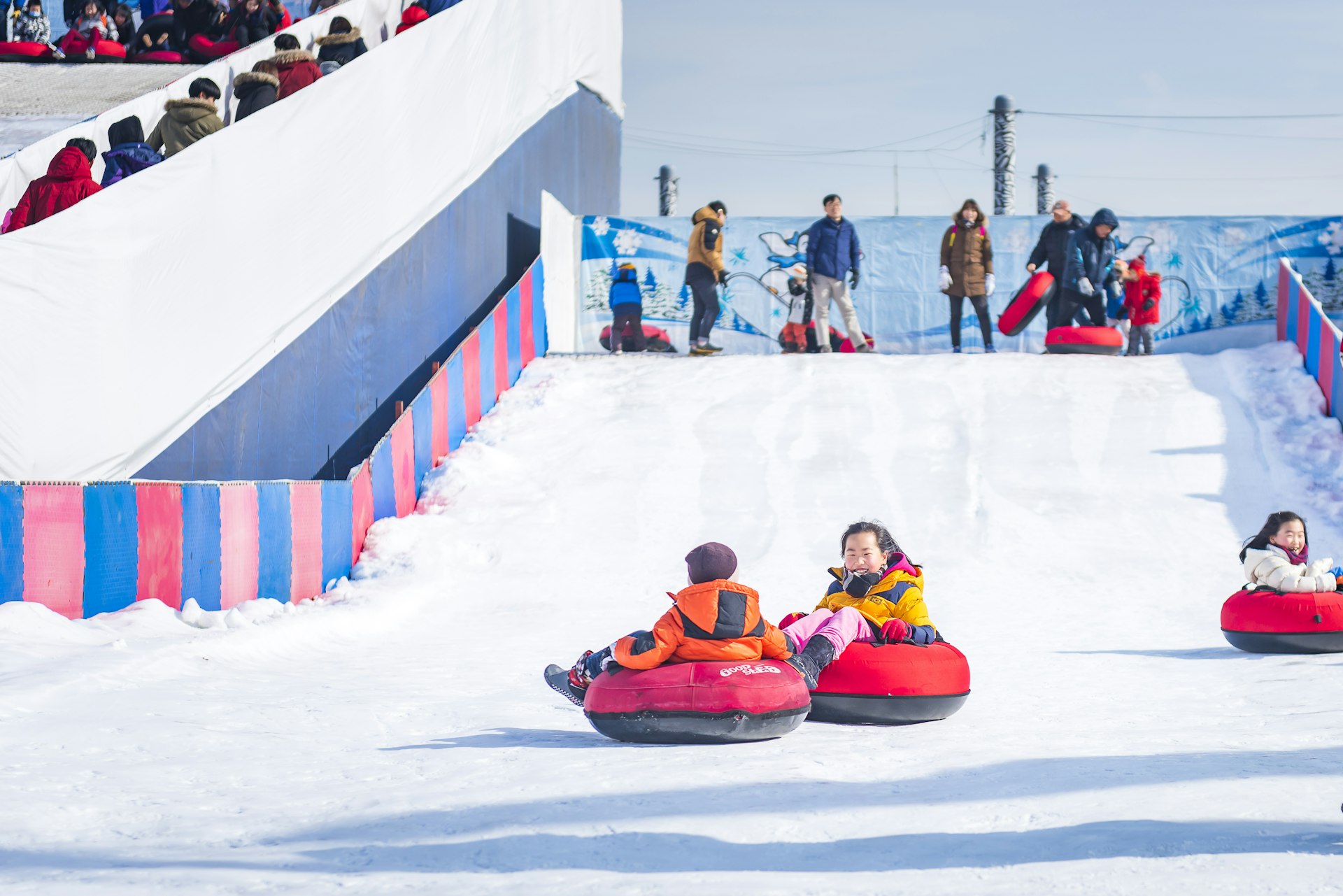 Children coast down snow-covered lanes in inner tubes in Seoul, South Korea