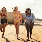 Happy multiracial females with different body size having fun walking on the beach during summer holidays