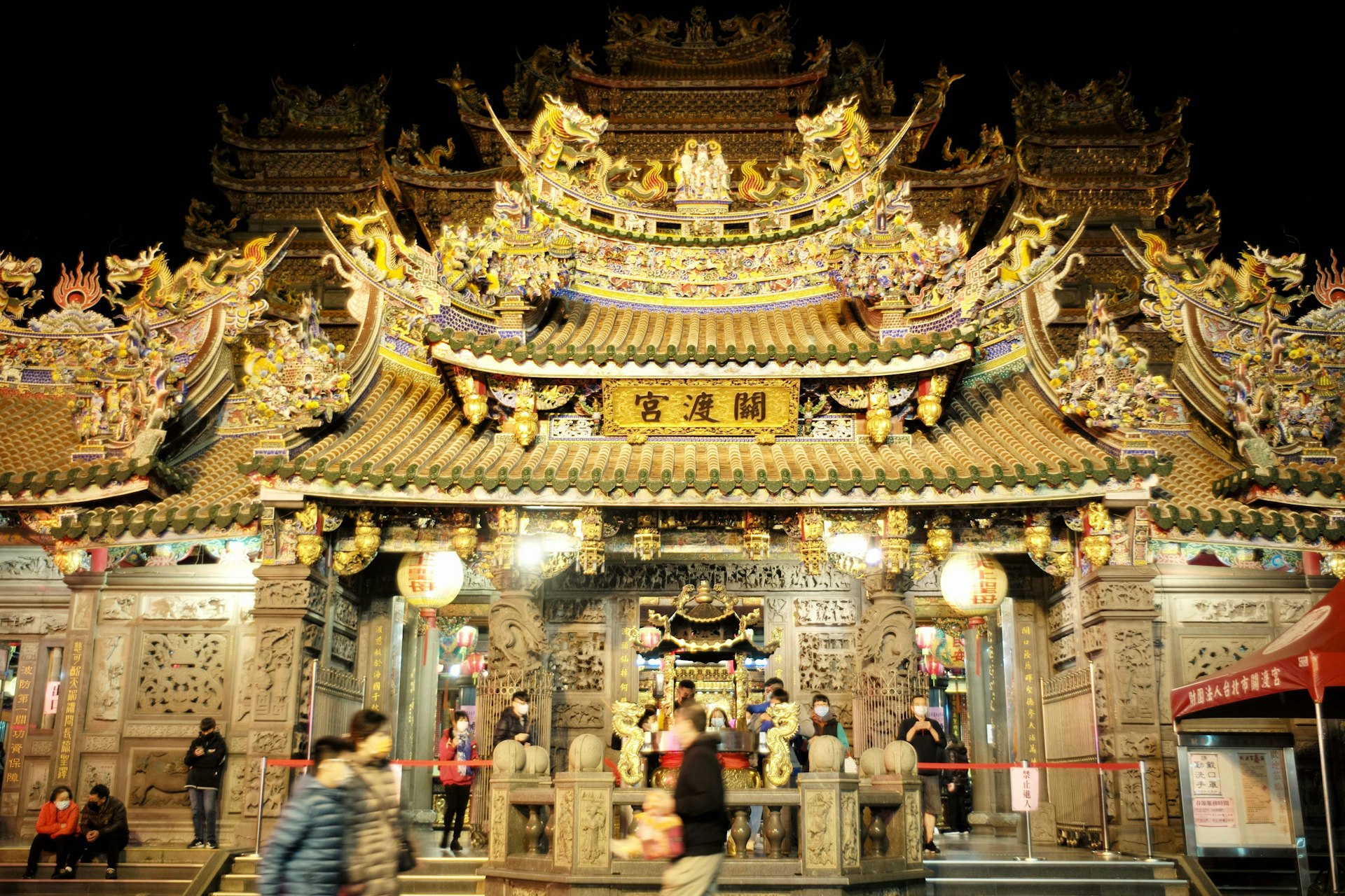 Local residents walk past in front of the golden Guandu Temple on the eve of Lunar New Year, Taipei, Taiwan