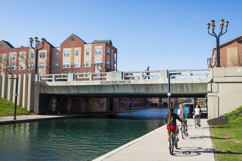 Indianapolis, Indiana, USA - April 10, 2015: Cyclists and pedestrians enjoy the good weather of a spring afternoon on the popular Canal Walk in Indianapolis, Indiana. The waterway is part of the historic Indiana Central Canal, constructed in the early 1800s.