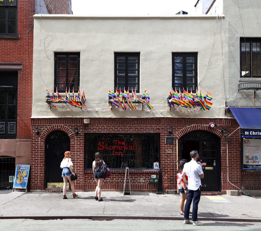 The exterior of the Stonewall Inn, a famous gay bar in New York City, with many rainbow flags flying from its walls
