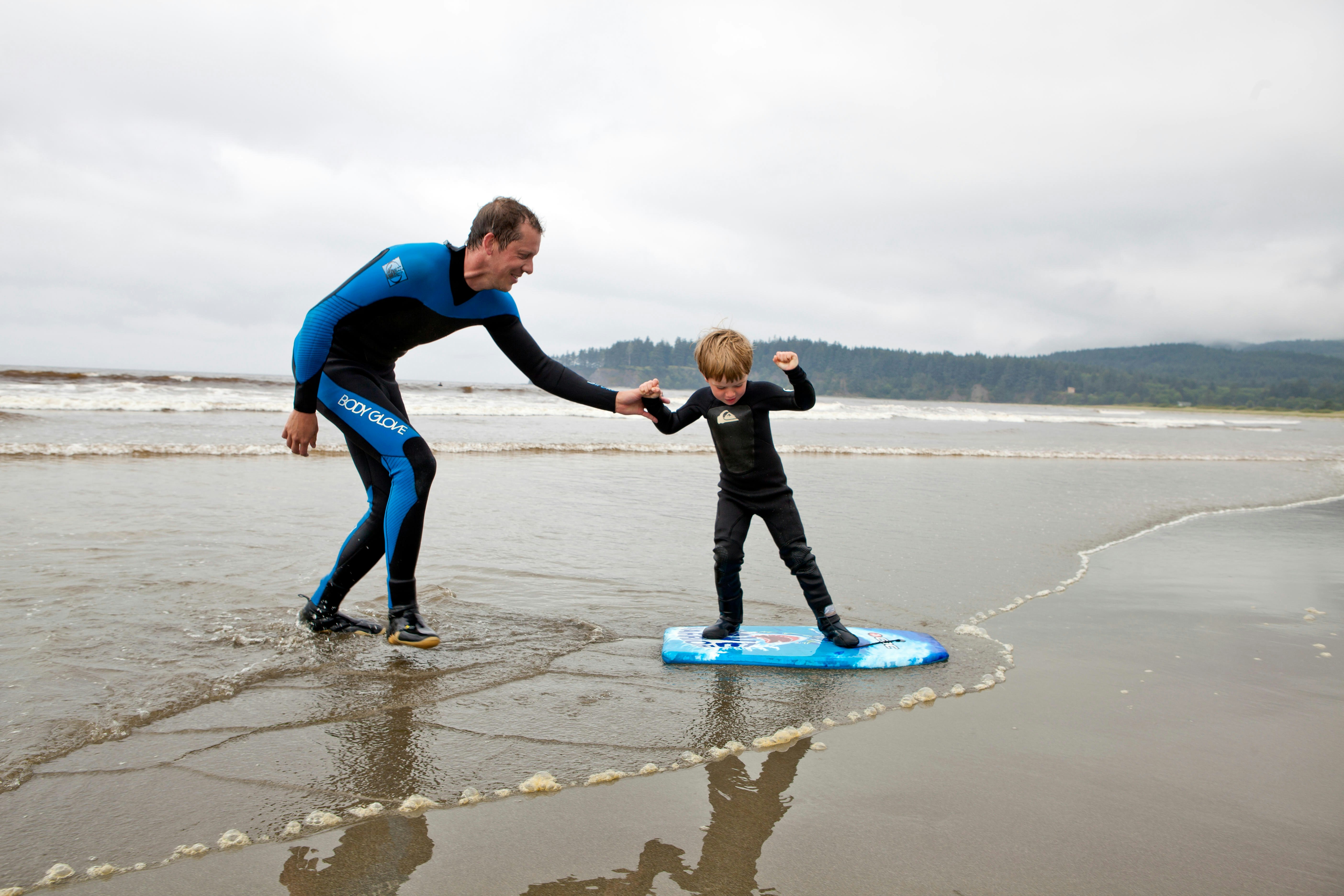 Nate Harrison teaching his son Gabriel how to surf, Hobuck Beach, Makah Reservation, Washington, USA