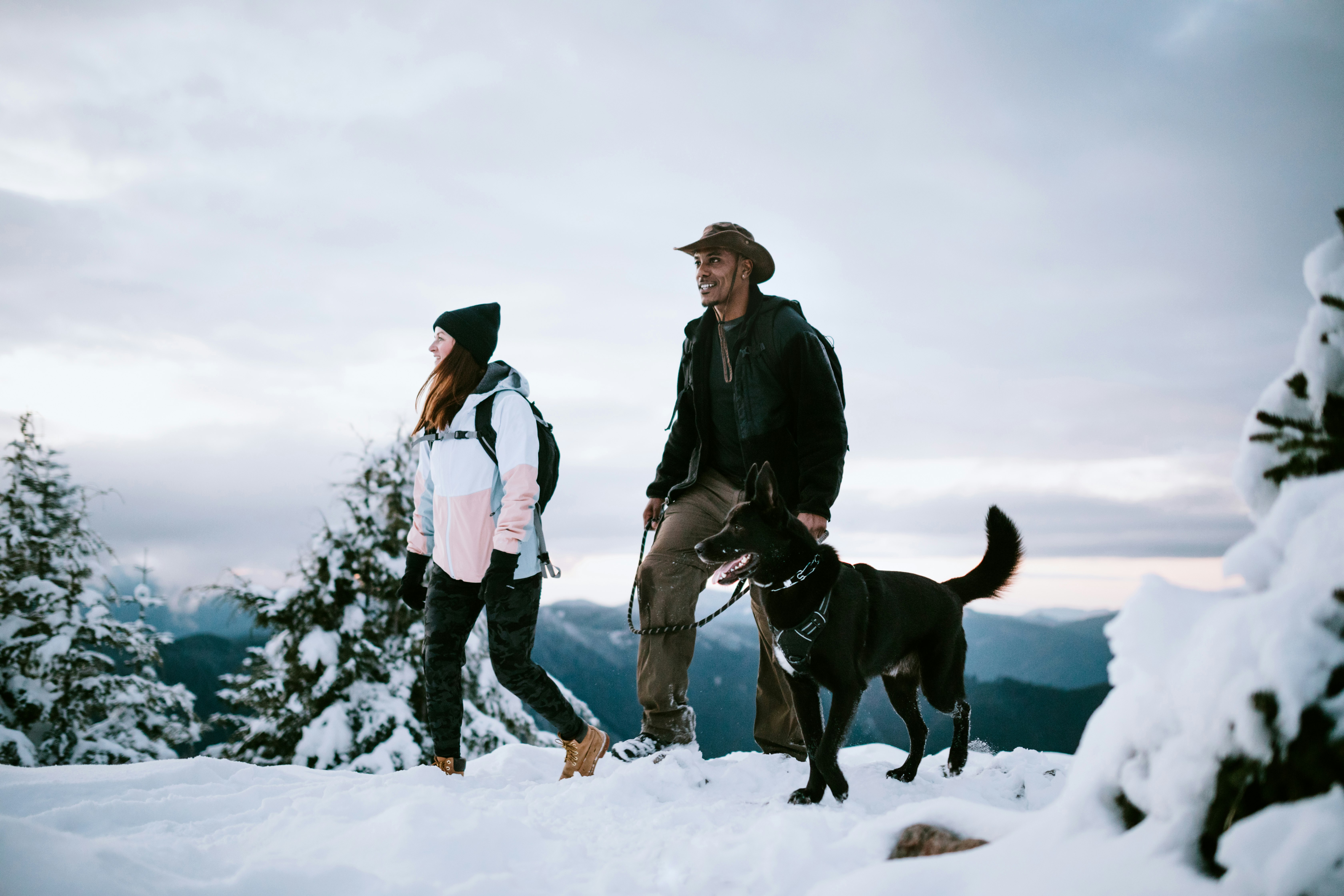 Two friends and a dog hiking in the snow in Washington state, USA