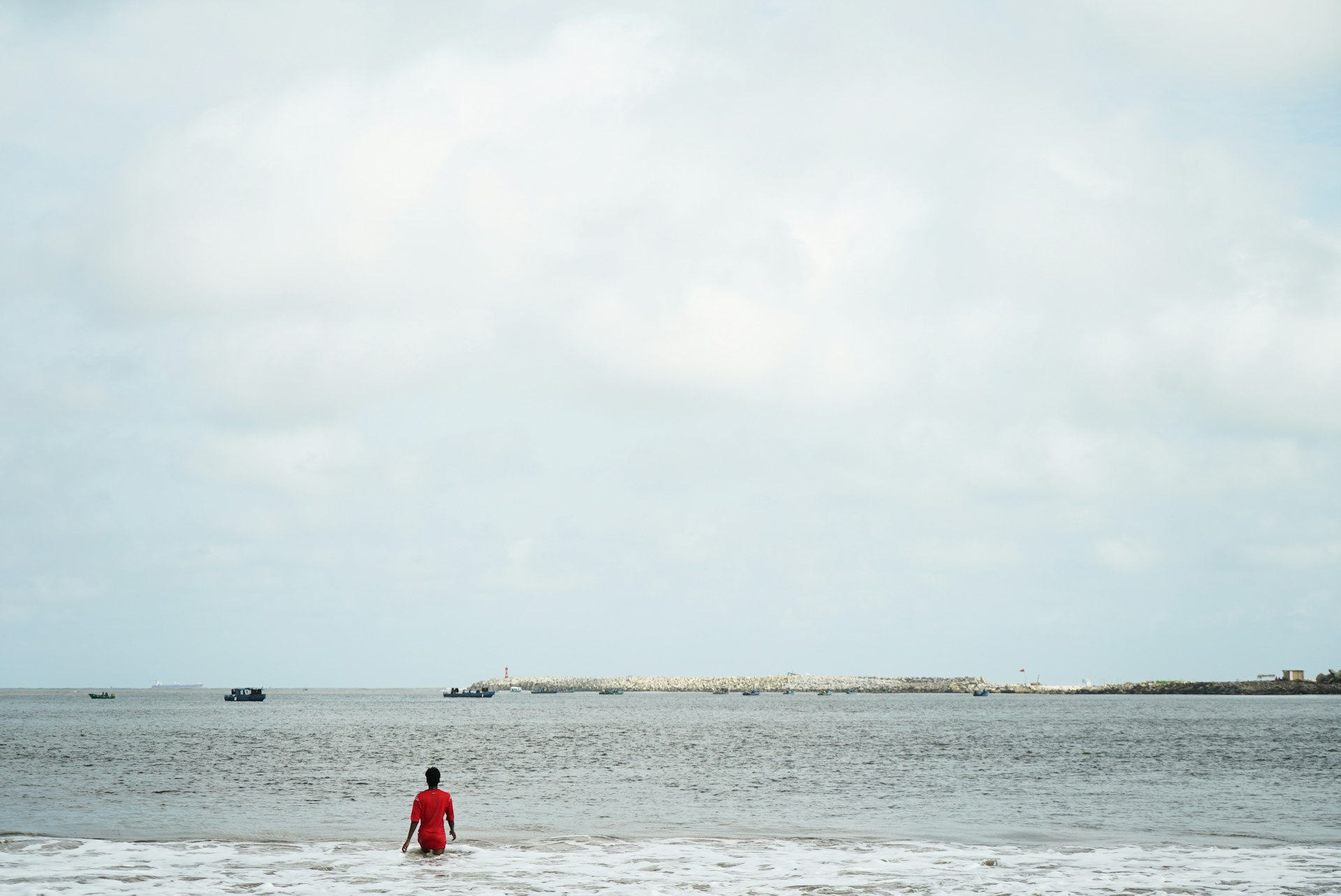 A single figure wades out into the water near Tarkwa Bay in Lagos 
