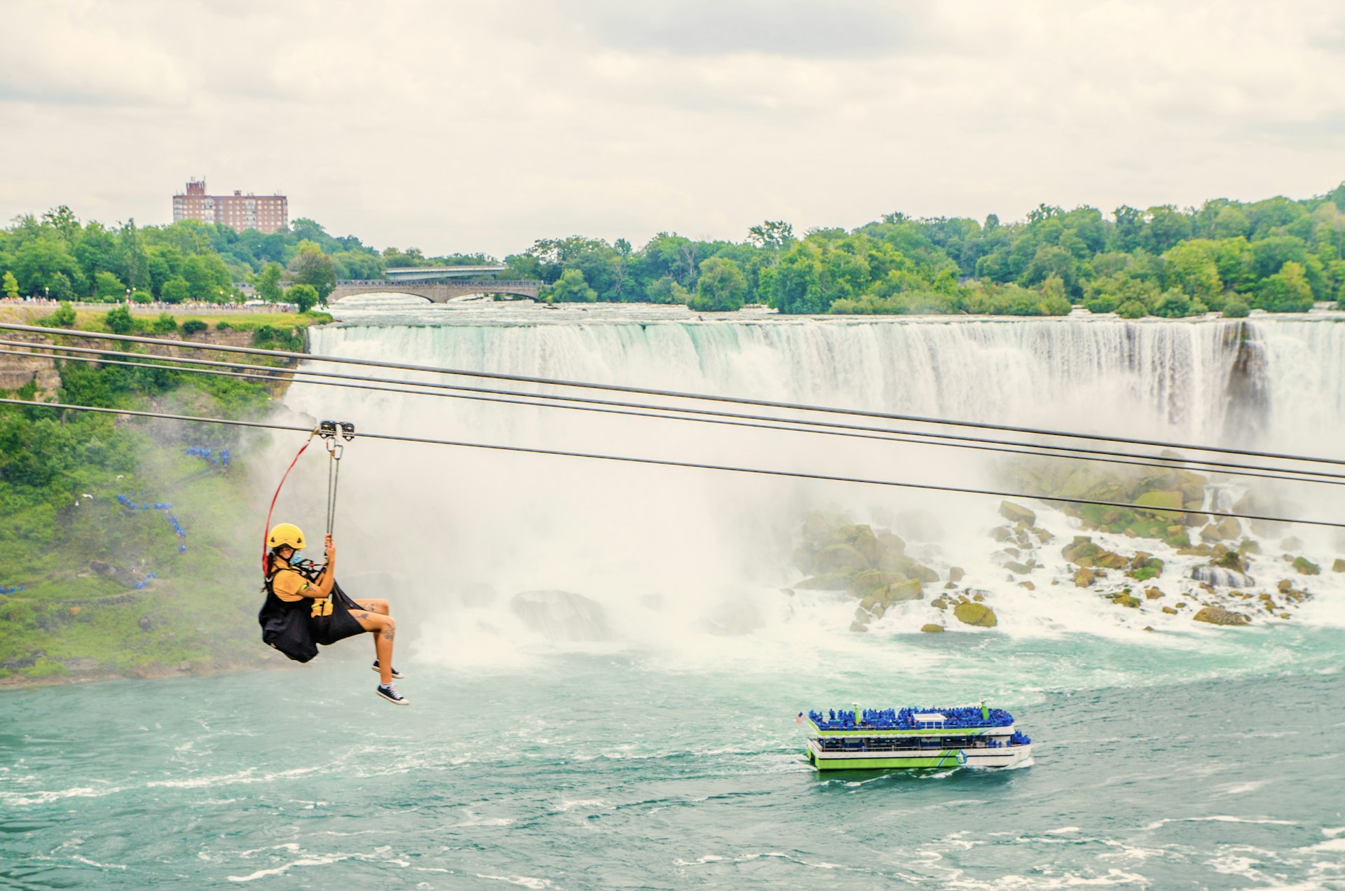 Woman going down zipline in front of Niagara Falls