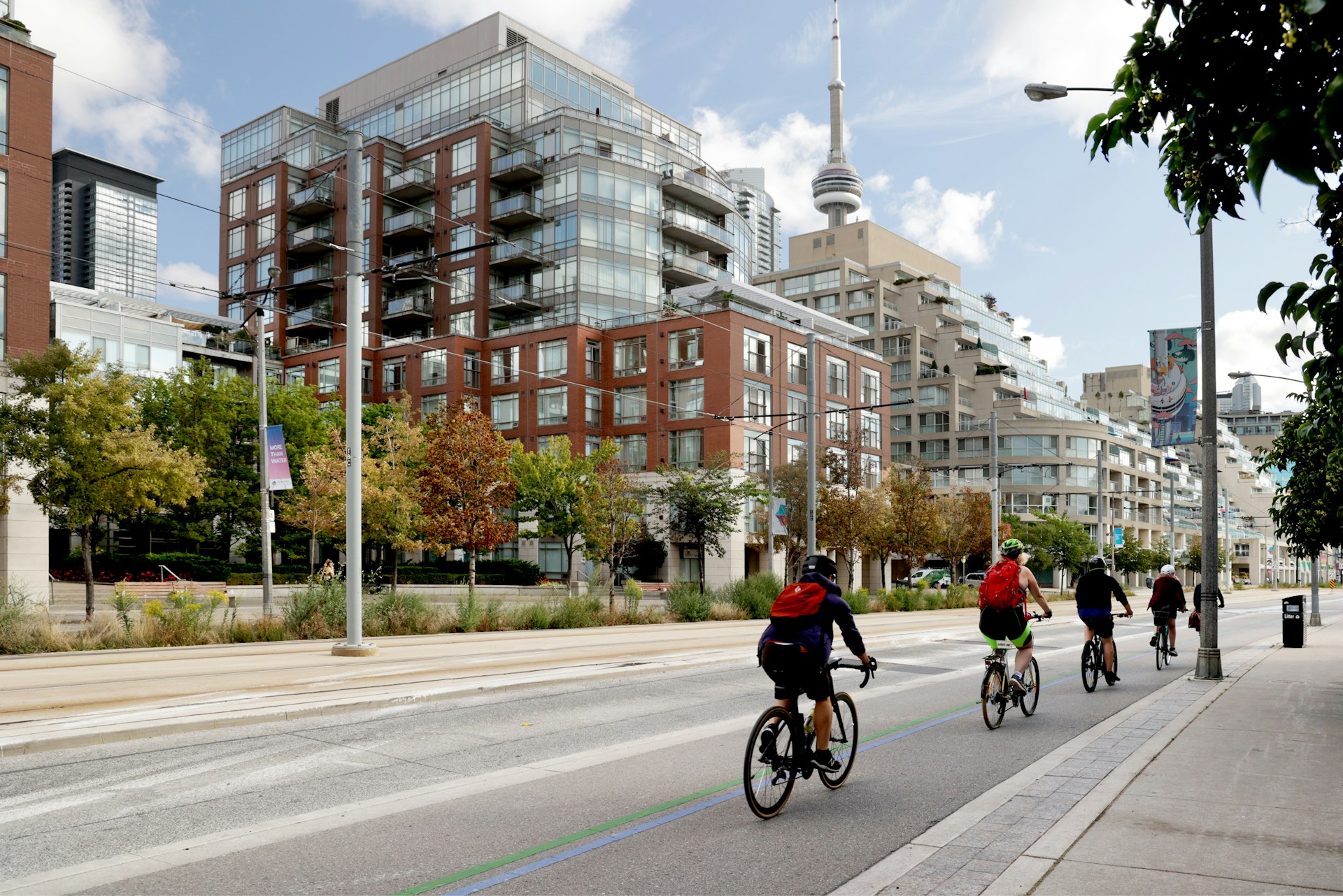 Cyclists ride bikes on an empty street in a large city