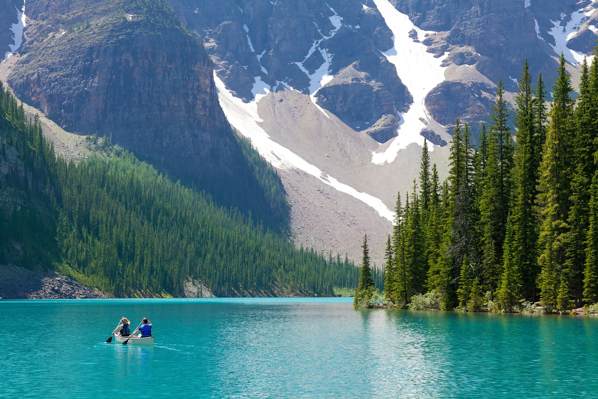 Boaters on a turquoise lake surrounded by mountains in Banff National Park