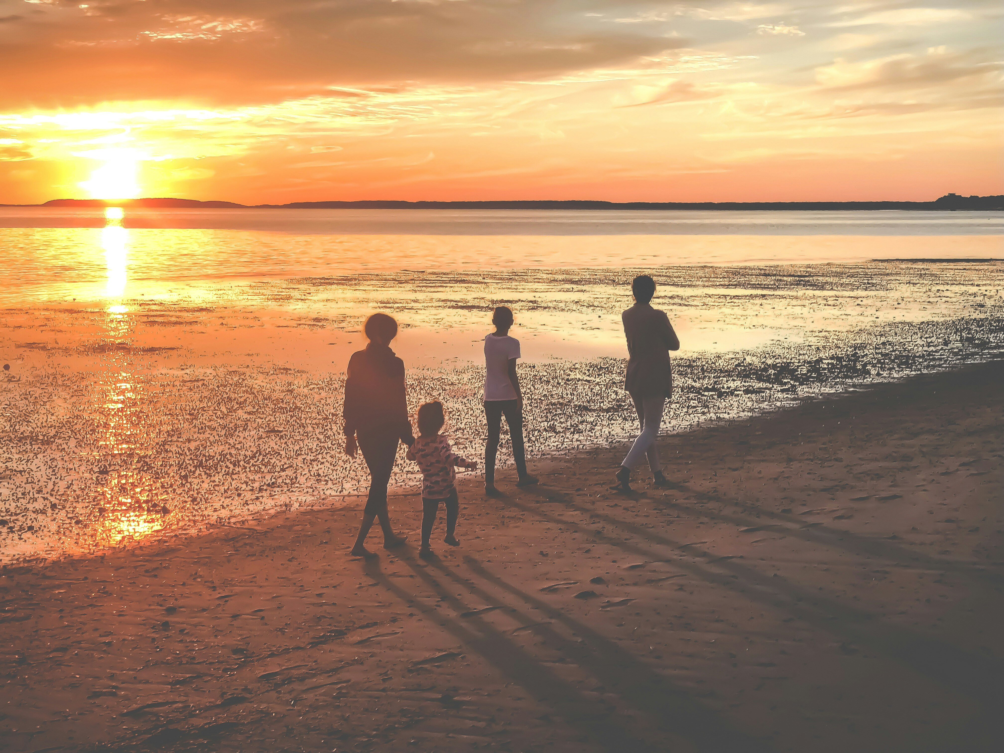 family enjoying sunset stroll on beach