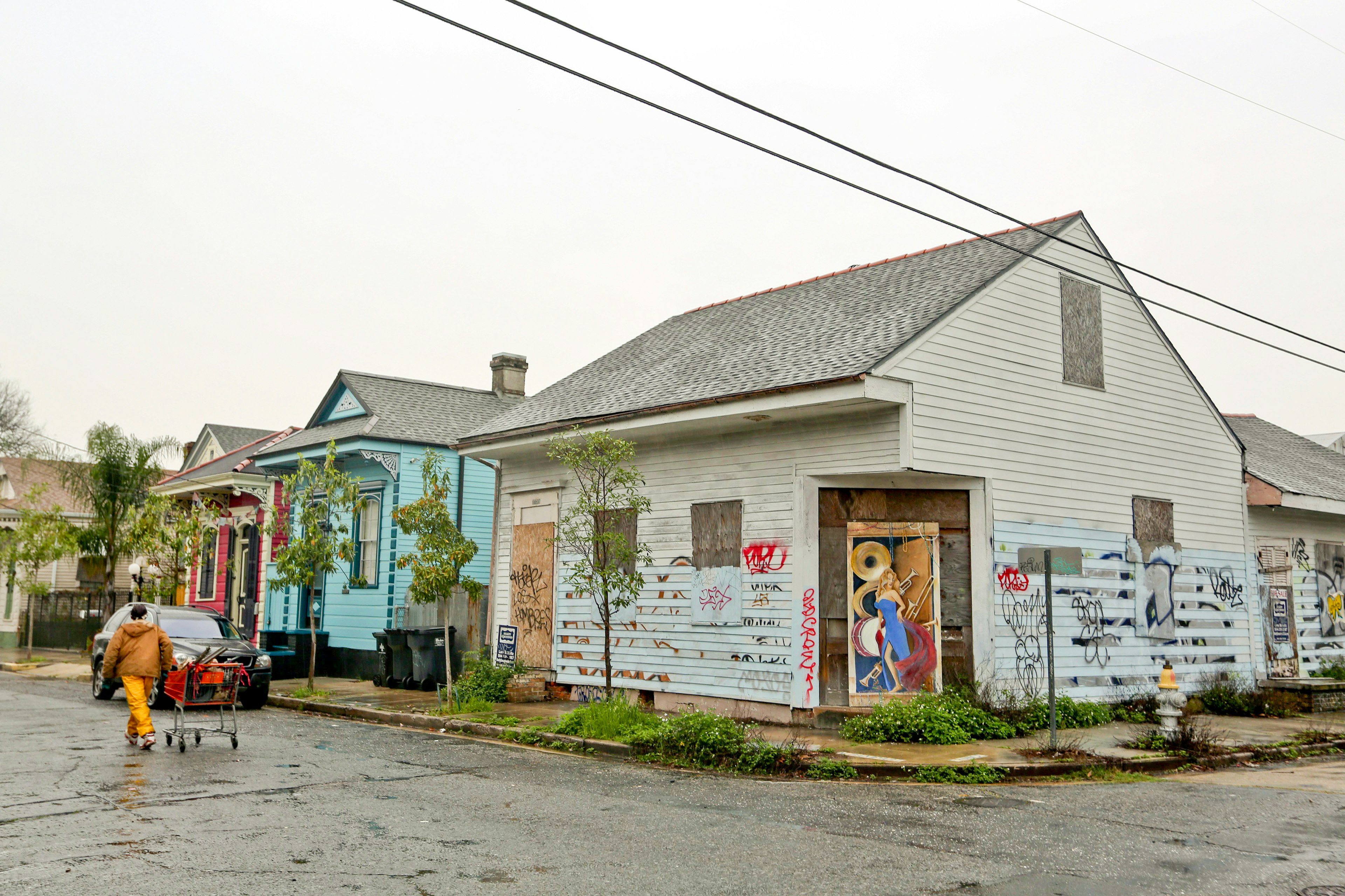 An abandoned, graffiti-covered home stands adjacent to occupied properties in the Bywater neighborhood of New Orleans