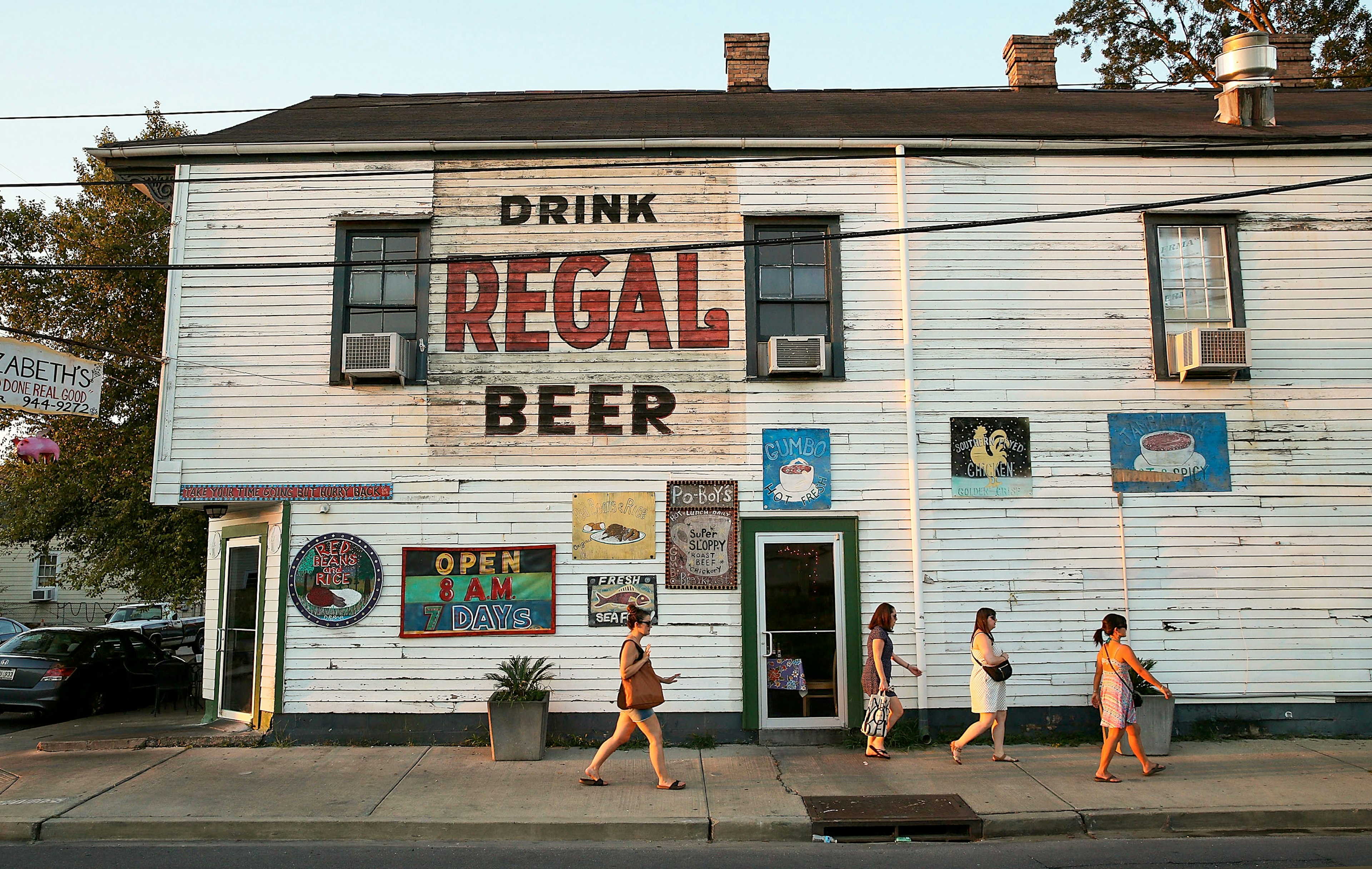 People walk past a restaurant in New Orleans, Louisiana