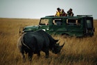 Safari Participants Watch Rhinoceros