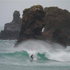 Unkown surfer surfing amongst rock stacks on the Isle of Lewis, West of Scotland.