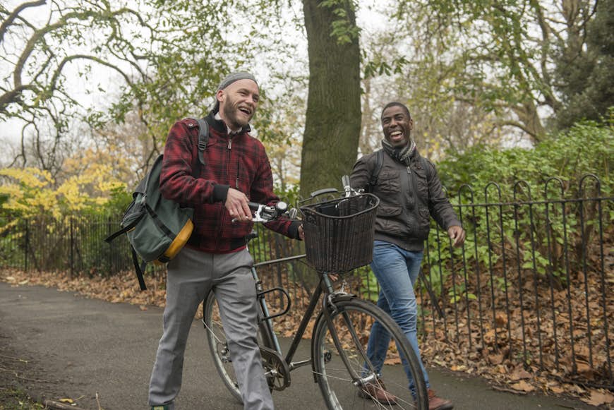 Two men chat as they wheel a bike through St Stephens Green in Dublin